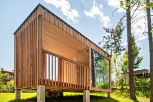 una casa di legno su pilastri di cemento in un campo di Schartneralm Kiefer Family a Collalbo