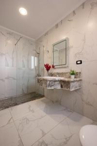 un bagno bianco con lavandino e specchio di A fully furnished villa with a private pool inside the Hydepark Compound in Fifth Settlement for rent a Il Cairo