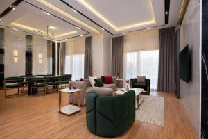 un soggiorno con un divano, sedie e un tavolo di A fully furnished villa with a private pool inside the Hydepark Compound in Fifth Settlement for rent a Il Cairo