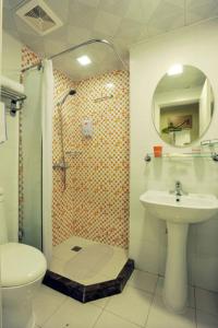 uma casa de banho com um chuveiro, um WC e um lavatório. em Home Inn Shanghai Nicheng Lingang Facility Industrial Park em Nanhui