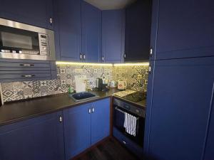 a kitchen with blue cabinets and a sink at Apartment Perfect in Pomorie