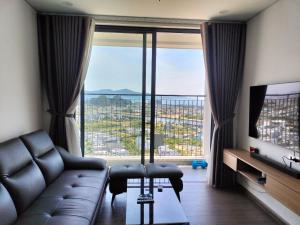 a living room with a couch and a large window at Căn penhouse 3 ngủ view biển FPT plaza 2 in Da Nang
