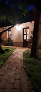 a brick walkway in front of a house at night at Lassu Tanya Vendégház in Nagykőrös