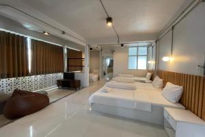 a large bedroom with two beds and a television at ASAYA House in Chiang Mai