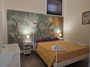 a bedroom with a bed with a painting on the wall at Vagabondando travel house in LʼAquila