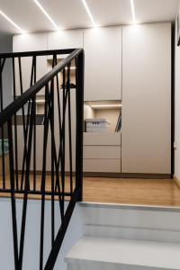 a staircase leading to a room with white walls and a kitchen at Széchenyi Center in Szeged