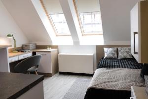 a bedroom with a bed and a desk with a chair at Széchenyi Center in Szeged