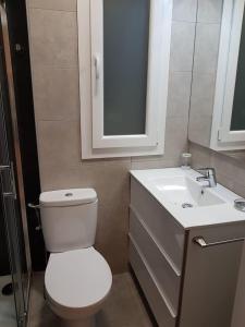 ein Badezimmer mit einer weißen Toilette und einem Waschbecken in der Unterkunft Donosti House con Parking ESS in San Sebastián + 2 Fotos