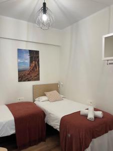 ein Schlafzimmer mit zwei Betten und einem Kronleuchter in der Unterkunft Donosti House con Parking ESS in San Sebastián