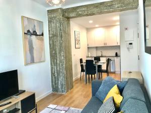 a living room with a blue couch and a kitchen at Donosti House Bi con Parking ESS2648 in San Sebastián