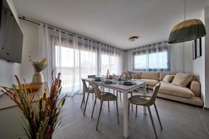 a living room with a table and chairs and a couch at Apartamentos Arenal 2 in Jávea