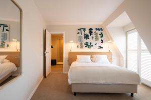 a bedroom with a white bed and a mirror at Made in Catherine in Brussels
