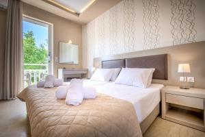 a bedroom with a large bed with white pillows at Nastazia Studios in Laganas