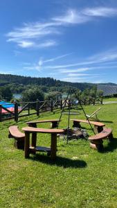 a group of picnic tables in a field at Dobra Miejscówka Domki nad Jeziorem Solińskim Jacuzzi 60 m od plaży 504-978-418 in Zawóz +10 photos