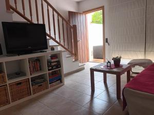 a living room with a flat screen tv and a table at Villa L'Estartit in L'Estartit