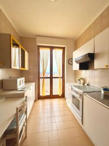 a kitchen with a large window with a view of the ocean at NURAS - Penthouse Antonietta with view in Alghero
