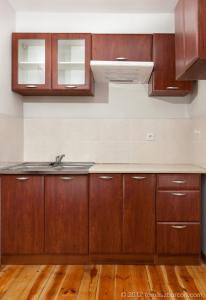 Una cocina con gabinetes de madera y un fregadero. en Hotelik Bach, en Gdansk