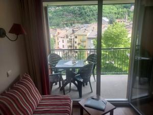 Una habitación con una mesa y sillas en un balcón. en Au coeur de l'Ariège, en Ax-les-Thermes