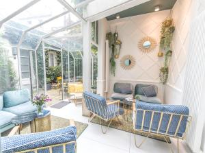 einen Wintergarten mit Stühlen, einem Sofa und einem Tisch in der Unterkunft Passy Eiffel in Paris