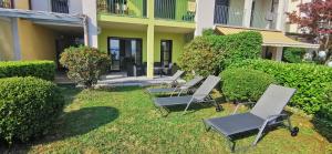 a group of chairs sitting in the grass in front of a building at Cielo D'Italia Stella in Cissano