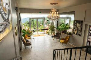 a hallway with chairs and a chandelier in a building at Alexain Hotel Restaurant & Wellness - Colmar Ouest in Trois-Épis