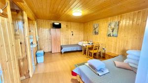 a room with a bed and a table in it at Dobra Miejscówka Domki nad Jeziorem Solińskim Jacuzzi 60 m od plaży 504-978-418 in Zawóz