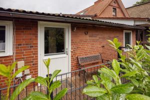 a brick house with a white door and a bench at Idyllisches Zimmer Im Grünen in Stelle