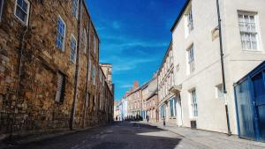 an empty street in an old city with buildings at St John's College in Durham