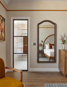 a bedroom with a mirror and a bed at Miiro Le Grand Hôtel Cayré in Paris