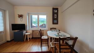 a living room with a table and chairs and a television at Hostdomus - Fox Suite in Sestriere +23 photos