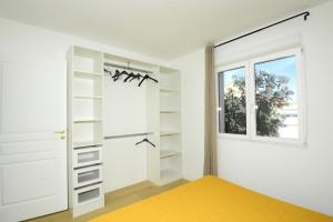a bedroom with white closets and a window at Les 2 dauphins in Le Barcarès +44 photos