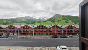 duży budynek z samochodami zaparkowanymi na parkingu w obiekcie Hostdomus - Fox Suite w mieście Sestriere