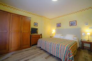 a hotel room with a bed and a television at Hotel Beau Sejour Pré-Saint-Didier in Pré-Saint-Didier
