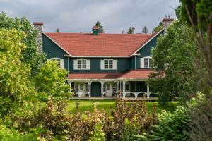 a large green house with a red roof at Le Baluchon Éco-villégiature in Saint-Paulin