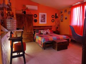 a bedroom with a bed and orange walls at El REFUGIO DE KARIM in San Rafael