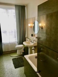 a bathroom with a sink and a tub and a toilet at La Marie-Thérése in Auxi-le-Château