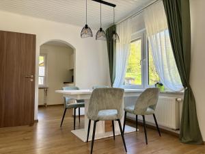 a dining room with a table and chairs and a window at Ferienwohnung in der Stegwiese in Kaifenheim