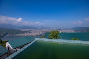a swimming pool with a view of a city and a river at Raniban Retreat in Pokhara