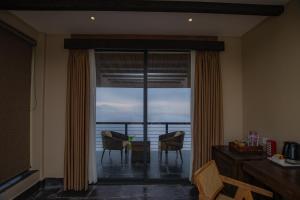 a room with a sliding glass door with a view of the ocean at Raniban Retreat in Pokhara