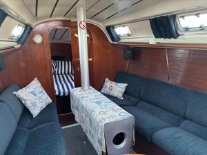 a living room with blue couches in a boat at Barco à Vela em Peniche - West Sailing in Peniche
