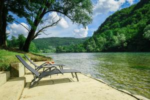a bench sitting on the shore of a lake at Vikendica Villa Natasa in Banja Luka