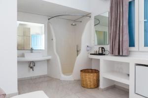 a white bathroom with a sink and a mirror at La Villa Rooms in Mikonos