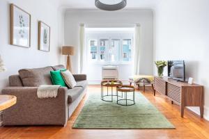 a living room with a couch and a tv at Casa da Avenida Lisboa in Lisbon