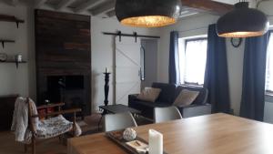 a living room with a couch and a table at Les Granges in Chaumot