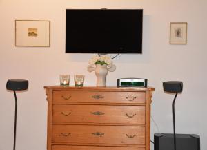 een televisie bovenop een dressoir met twee glazen bij Ferienhaus 1534 in Neustadt an der Weinstraße