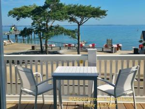 a table and chairs on a balcony with the ocean at Ferienhaus Urban Fewo Beletage 2 bis 6 Personen mit Panorama Meerblick WLAN gegenüber vom Strand in Häven