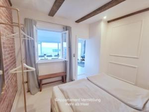 a bedroom with a bed and a door with a window at Ferienhaus Urban Fewo Beletage 2 bis 6 Personen mit Panorama Meerblick WLAN gegenüber vom Strand in Häven