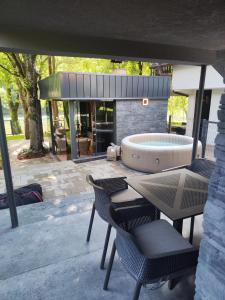 a patio with chairs and a tub in a building at Vikendica Villa Natasa in Banja Luka