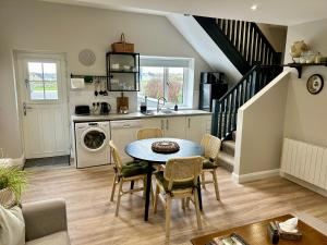 a kitchen and dining room with a table and chairs at The Mourne Hideaway in Annalong
