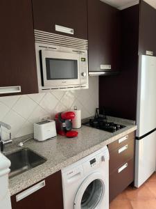 una cucina con lavatrice e microonde di San Antonio 6 a Malpartida de Cáceres